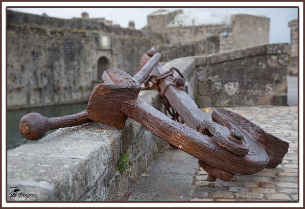 Ein Denkmal steht in der Nähe eines Sees mit einem klaren Himmel darüber und mehreren Schildern in der Umgebung.