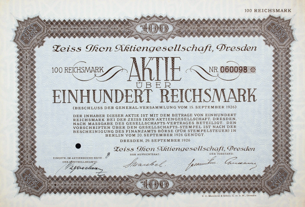 Ein altes deutsches Aktienzertifikat mit schwarzem Rand, auf dem der Text "Aktie über Einhundert Reichmark" steht