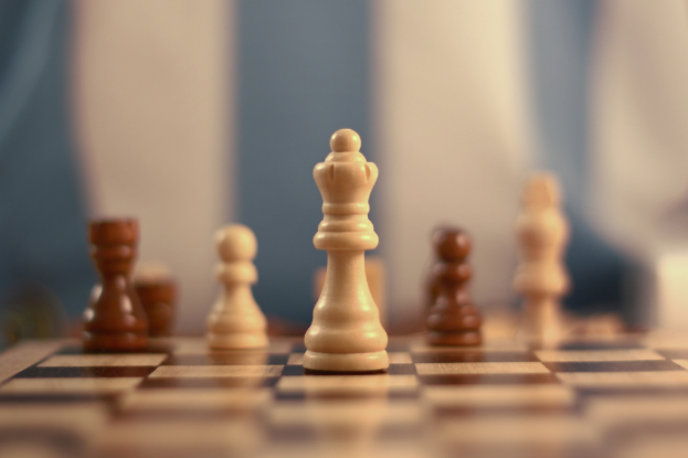 Ein Schachbrett mit Schachfiguren vor einem unscharfen Hintergrund.