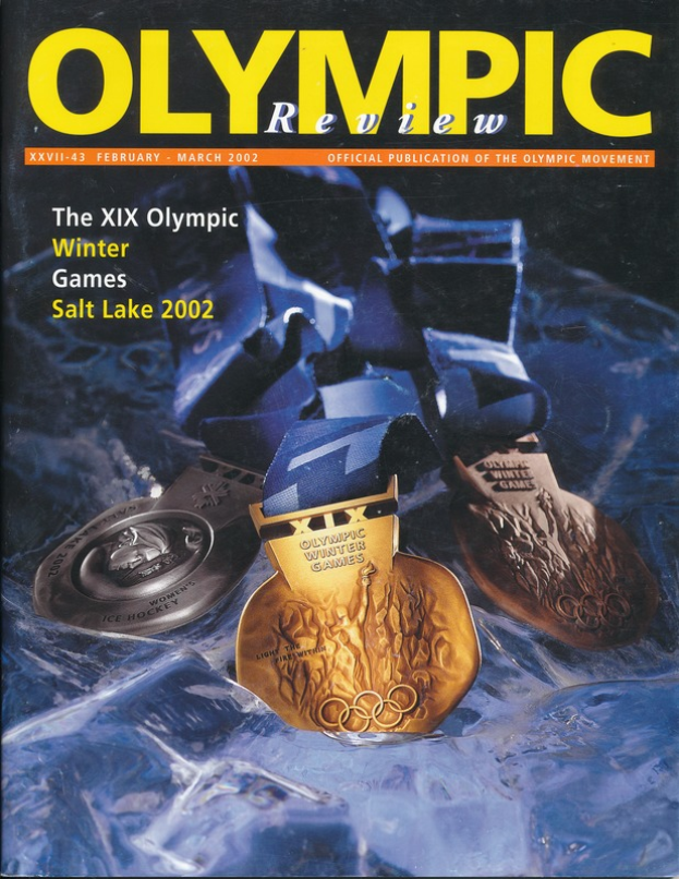 Ein Buch mit dem Titel "Olympische Spiele-Rezension" mit mehreren Medaillen in verschiedenen Größen und Farben und fetter Schrift auf dem Cover.