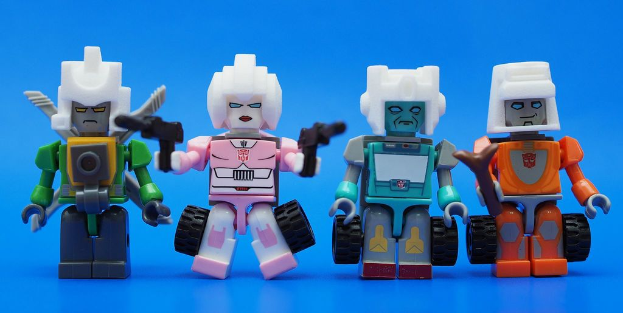 Vier Roboter-Spielzeuge sind auf einer blauen Oberfläche platziert.