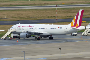 Germanwings Airbus A320-200 am Frankfurt Airport mit Bodenfahrzeugen, Verkehrszeichen, Versorgungsmasten und Grasfläche im Hintergrund.