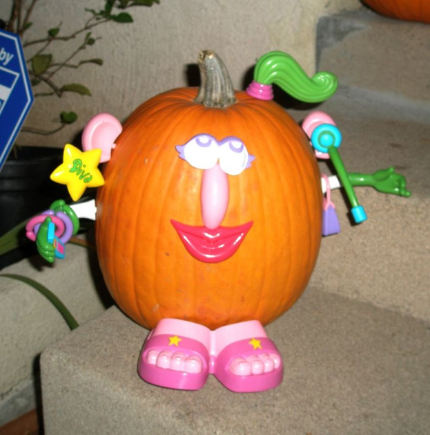 Eine Pumpkin auf der Treppe mit Spielzeugen darauf, eine Pflanze und ein blaues Objekt links und eine weitere Pumpkin oben.