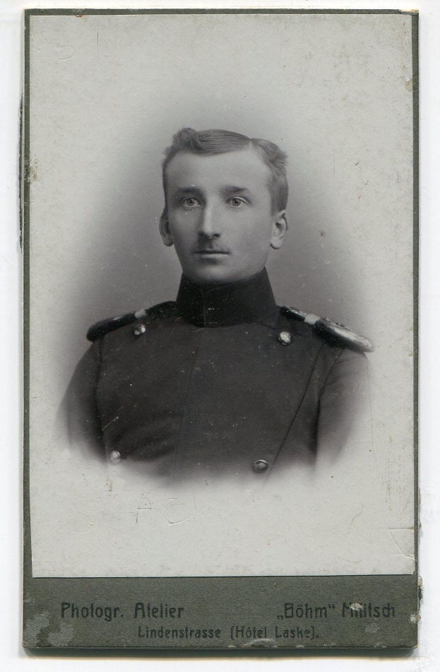 Ein Schwarz-Weiß-Foto von Adolf Hitler in Uniform mit ernstem Gesichtsausdruck und Text unten.