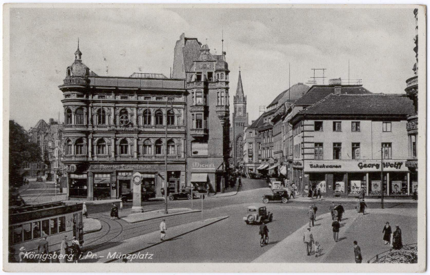 Schwarzes und weißes Foto einer belebten Münchner Stadtstraße mit Fußgängern, Fahrzeugen und Gebäuden, Bäumen im Hintergrund und Text unten.