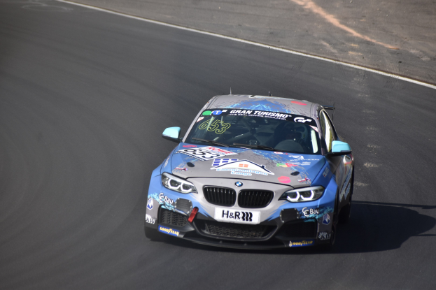 BMW M2 GT3 Rennauto auf einer Rennstrecke mit sichtbaren Text und Zahlen am Körper.