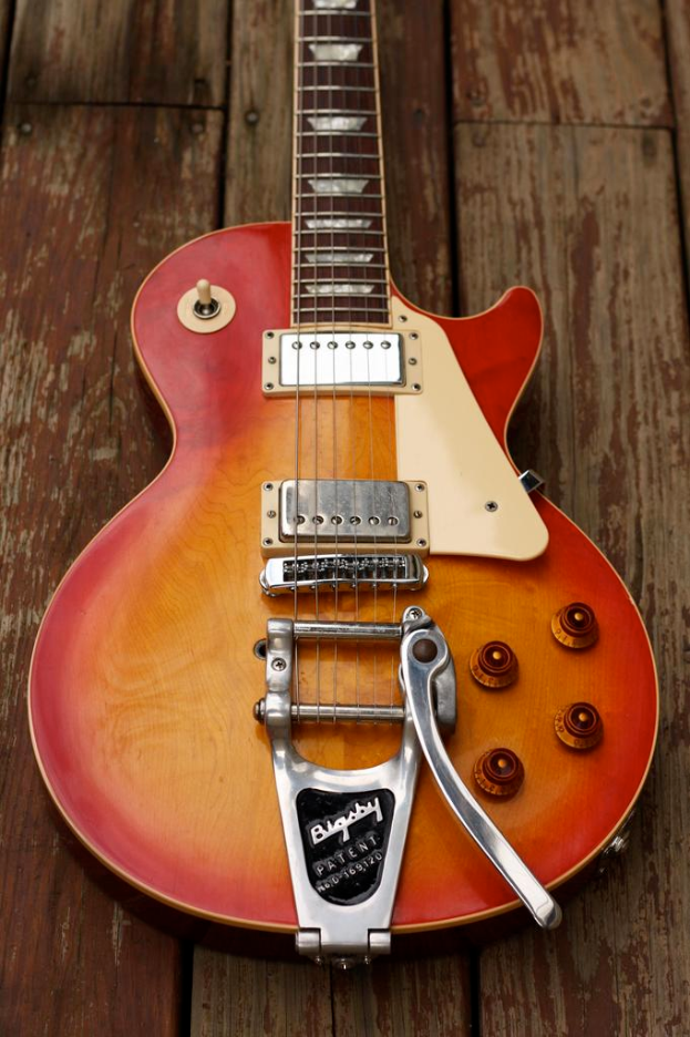 Eine Gitarre auf einem Holzbrett liegend.