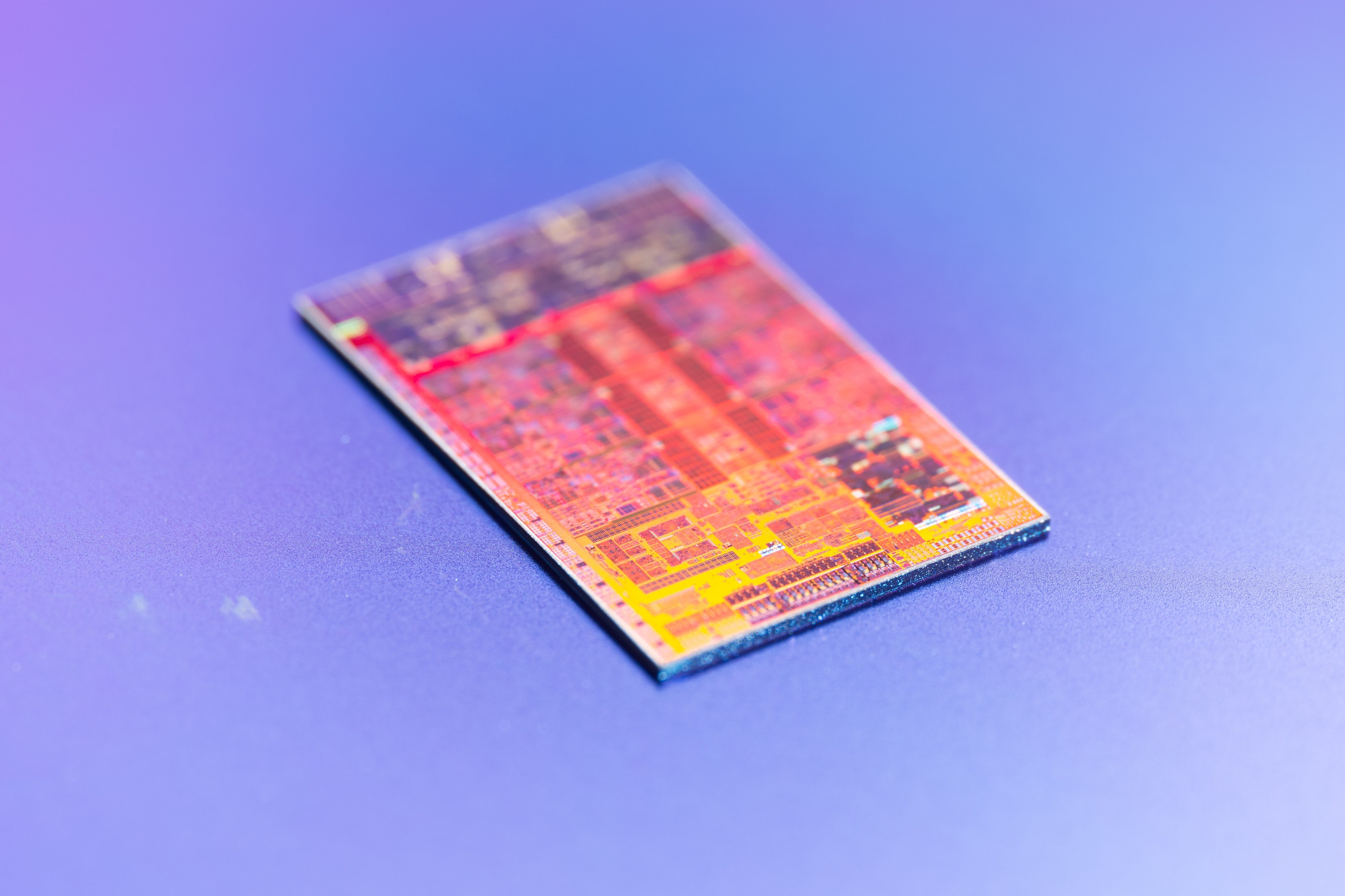Nahaufnahme eines Mikrochips, der als neuer Intel-Prozessor gekennzeichnet ist, auf einer blauen Oberfläche.