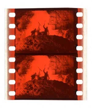 Ein Filmstreifen mit einem gedämpften, traurigen Bild einer Gruppe von Menschen in Not vor einem weißen Hintergrund.