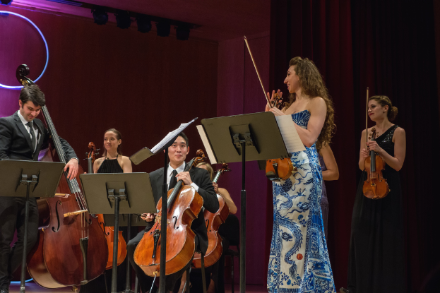 Ein Vorhang mit ein paar Leuten, die Gitarren halten, davor.