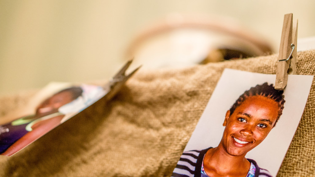 On a table, there is a clip, a passport size photo, and a piece of cloth on the right side, with a blurred background and left side.