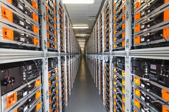 Lange Reihe von Servern in einem Rechenzentrum mit elektronischen Geräten in den Racks und Anzeigelampen oben.