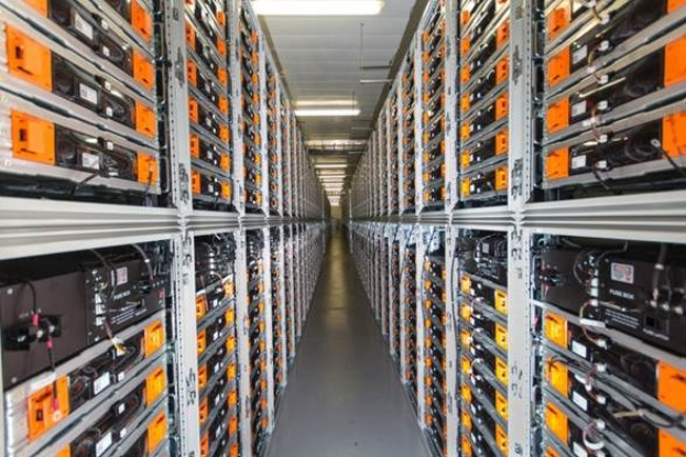 Lange Reihe von Servern in einem Rechenzentrum mit elektronischen Geräten in den Racks und Anzeigelampen oben.