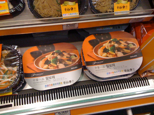 Lebensmittelboxen in Regalen mit Preiszetteln