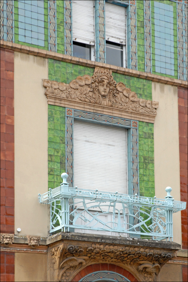 Ein an einer Wand angebauter Unterstand mit zwei Fenstern und einer Fensterjalousie oben sowie einem Gebäude rechts daneben.
