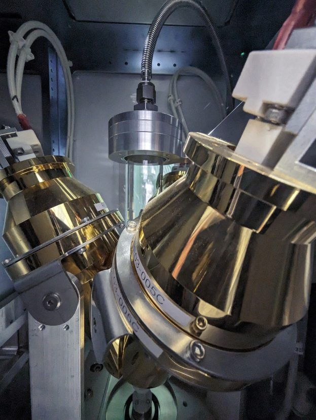CNC-Fräsmaschine in einer Fabrik mit einem Metallobjekt im Vordergrund und einer Wand im Hintergrund, die Werkzeuge und Komponenten am Metallobjekt zeigt.