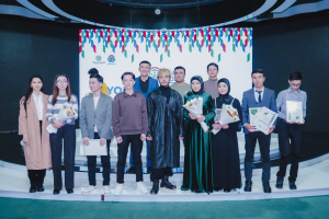 Gruppe von Menschen auf einer Bühne mit Blumensträußen und Urkunden vor einem "Jugend-Solar-Awards-2019"-Hintergrund.