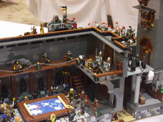 Ein altes, unbenutztes Fabrikinnere mit Maschinen, Schutt auf dem Boden, Fenstern und Geländern auf beiden Seiten.