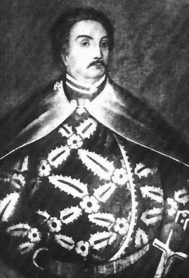 Schwarzes und weißes Foto von Papst Johannes Paul II. in Priesterrobe, der eine schwarze Robe mit weißem Kragen und Manschetten trägt und die Hände gefaltet hat, mit ernstem Gesichtsausdruck und direktem Blick.